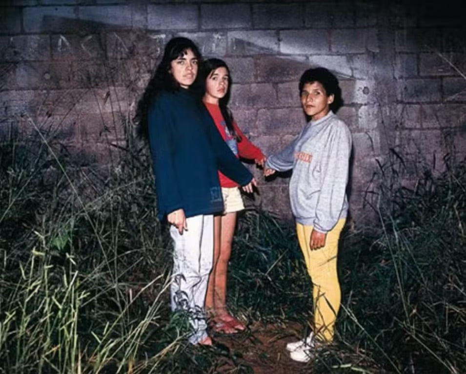 Em foto da época, Liliane, Valquíria e Kátia mostram onde viram uma estranha criatura de corpo amarronzado; em princípio, acharam que fosse o 'demônio' — Foto: Polícia Militar / Wikimedia Commons